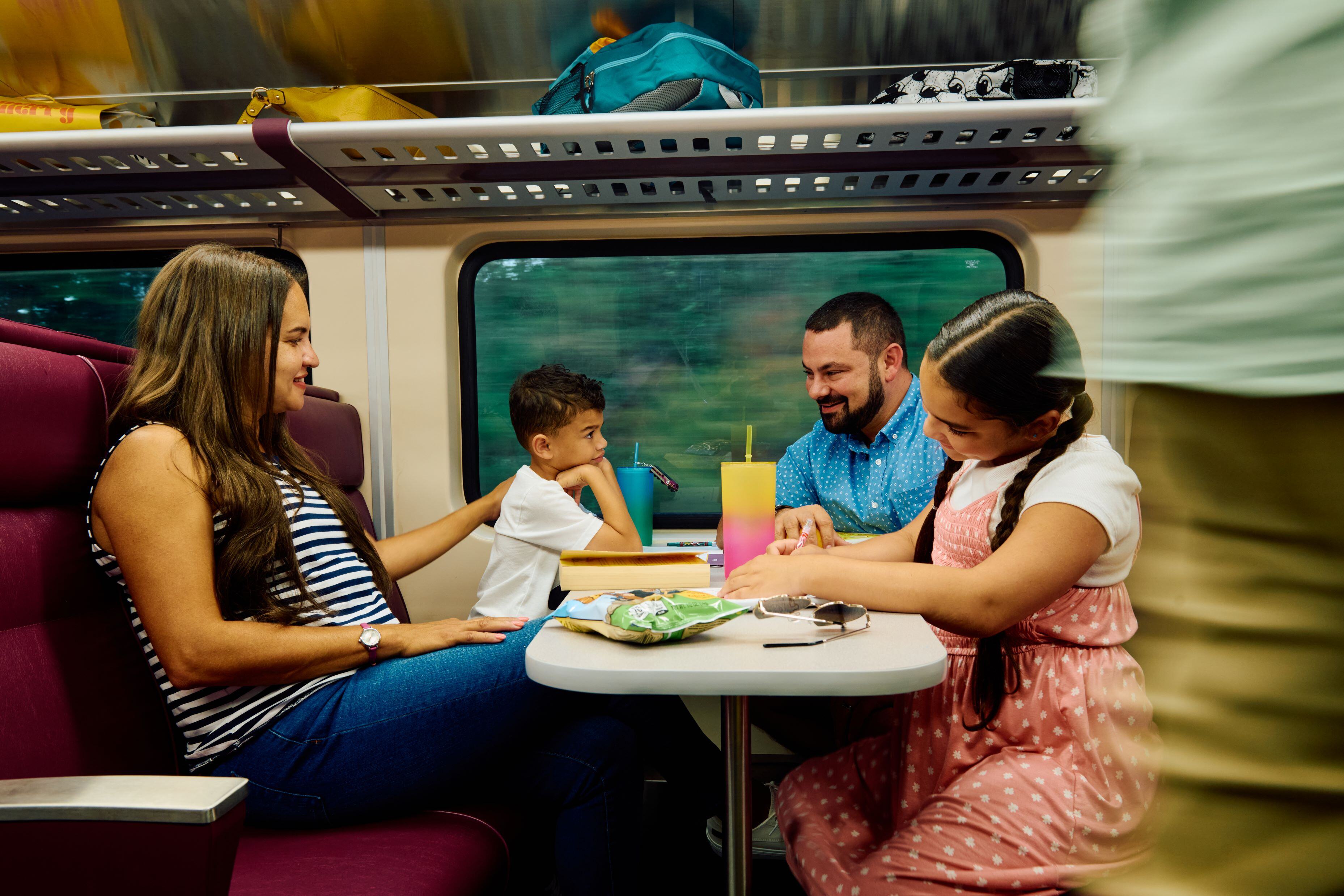 A family rides a commuter rail train