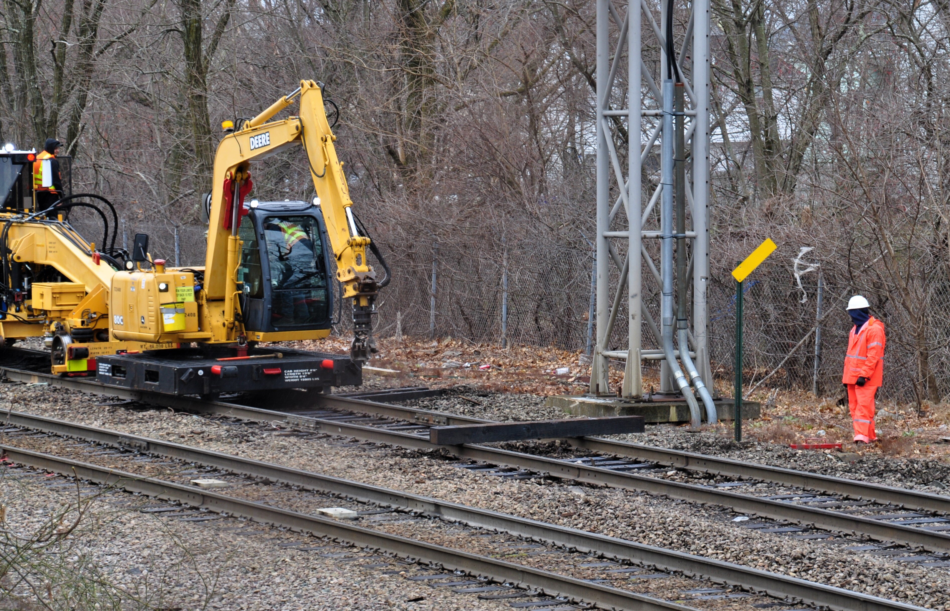 A crew works with heavy machinery to repair train tracks