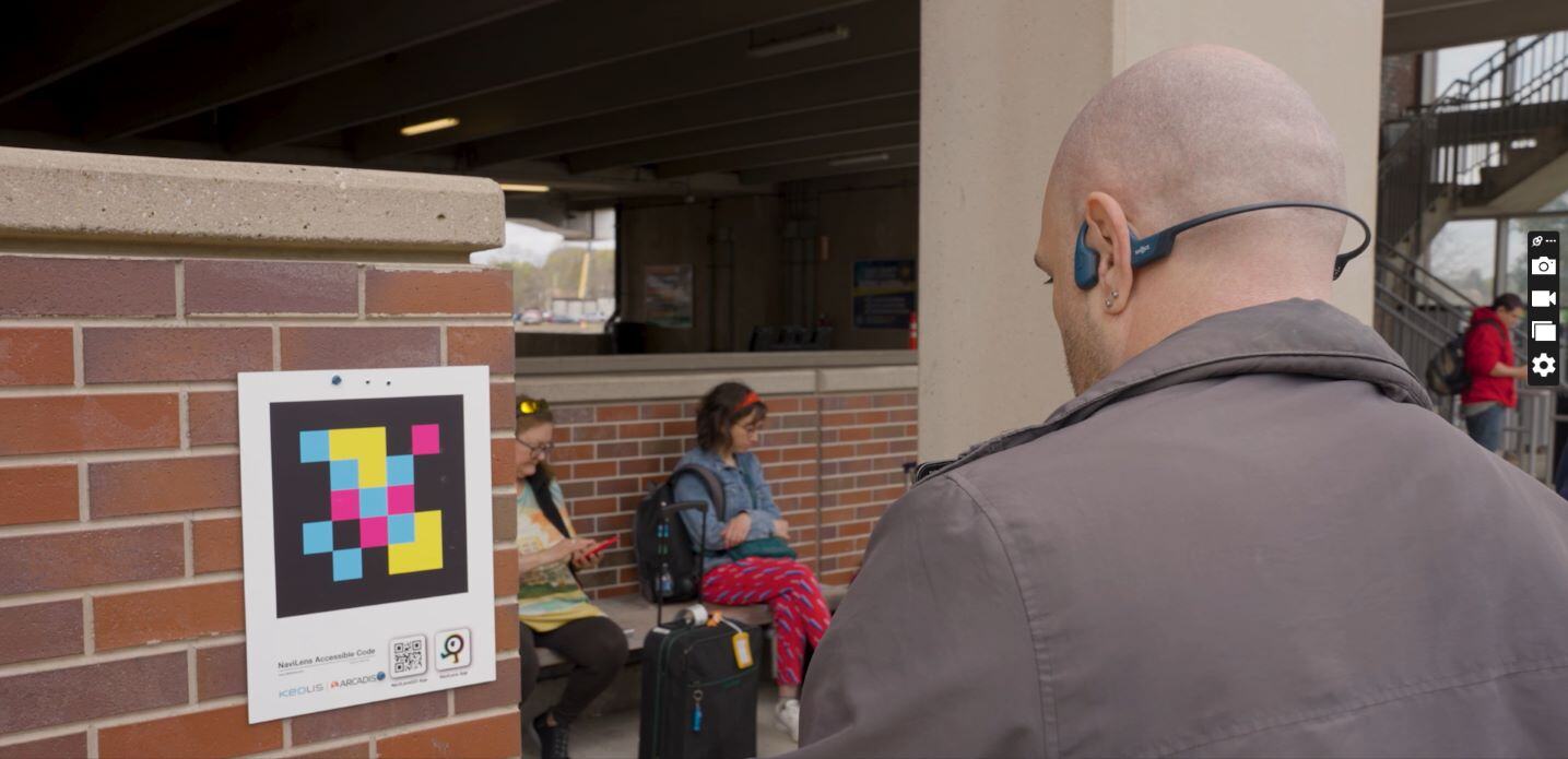 A passenger looks at a NaviLens code to help navigate Salem Station